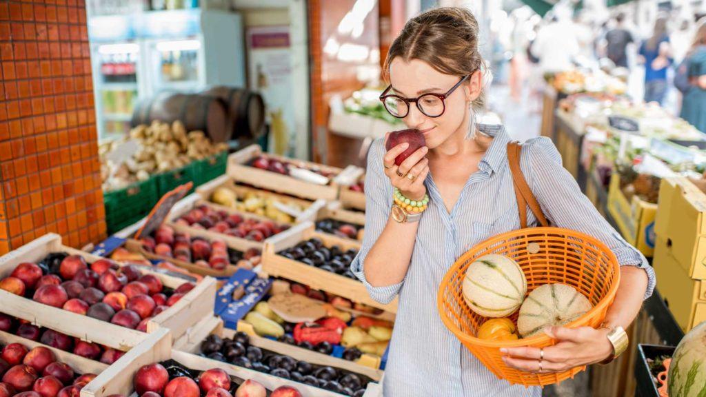 femme en train de choisir des fruits au marché